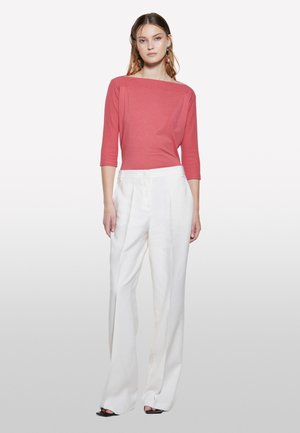 Haut ajusté corail à manches trois-quarts et pantalon large taille haute blanc avec une texture lisse et des détails plissés.