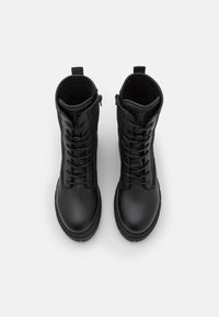 Pair of black leather lace-up ankle boots with side zippers, viewed from above on a white background.