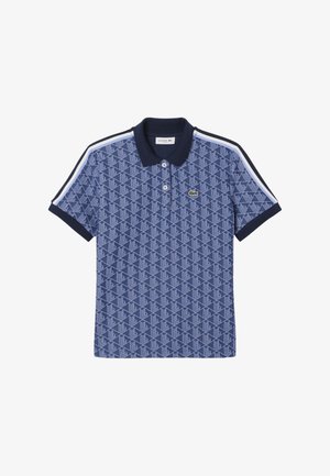Mørkeblå polo t-shirt med et geometrisk mønster. Har klassisk krave, tre knapper og kontrasterende hvide sidelister. Lacoste-logo på brystet.