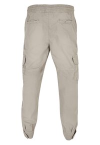 Beige cargo bukser med elastisk talje, flere sidelommer, smalle ben og en glat, let stofstruktur.