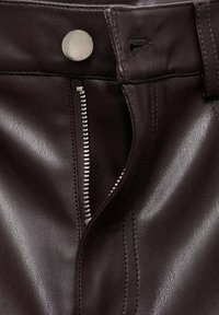 Dark burgundy leather pants with a silver metal button and a zipper closure. Textured finish, with visible stitching details.