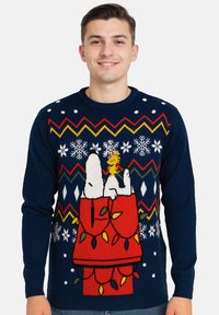 Maglione lavorato a maglia blu navy con Snoopy e Woodstock, decorato con vivaci accenti rossi. Include fiocchi di neve e motivi a zigzag in vari colori.