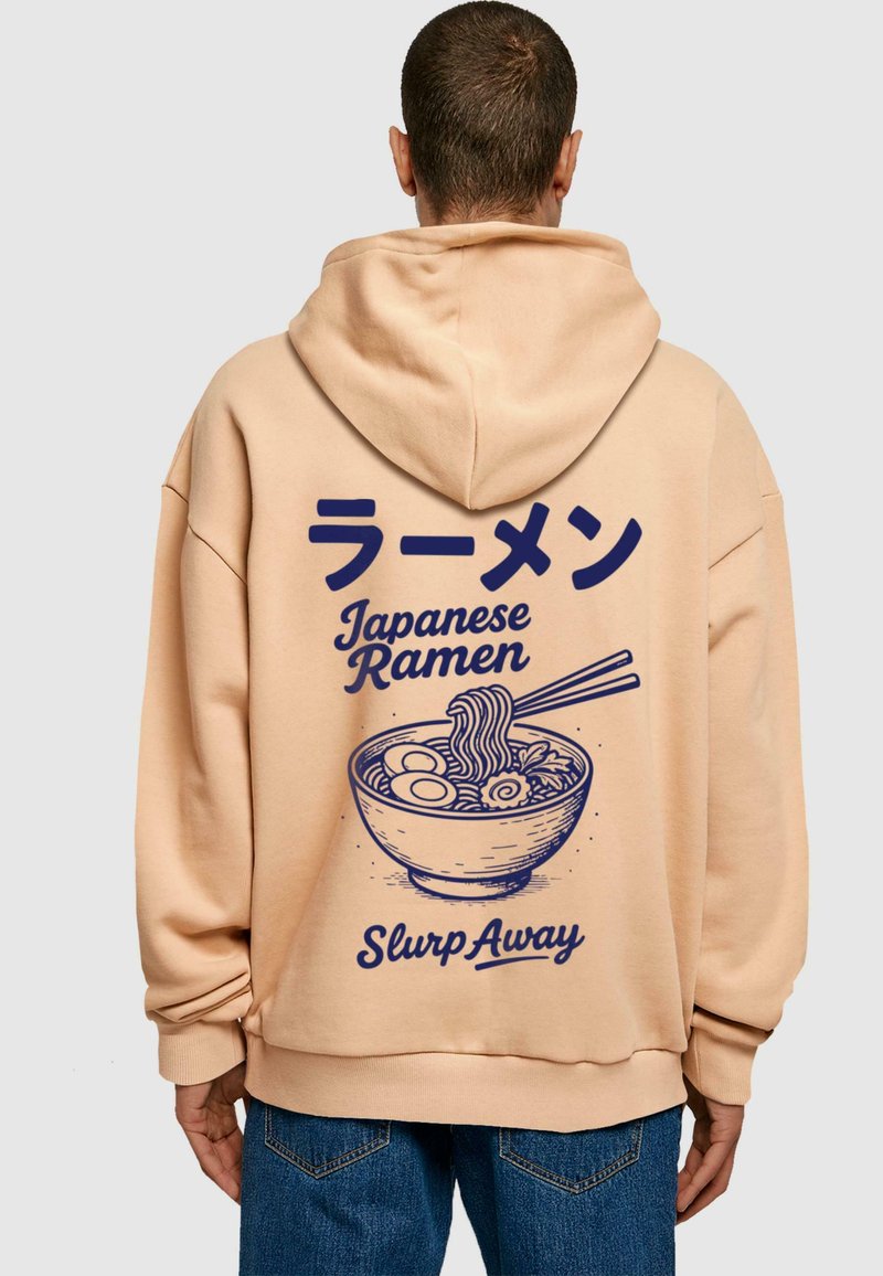 Sudadera color beige con un gráfico en azul marino de un tazón de ramen con fideos y huevos, texto en japonés e inglés, corte relajado.