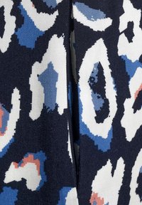 Ciemny materiał z nieregularnymi abstrakcyjnymi plamami w kolorze białym, niebieskim i koralowym, z widocznym centralnym szwem i teksturowanym splotem.