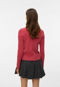 Pulover iz pletenine s kitami, globoko rožnate barve z dolgimi rokavi, rebrastim robom in pogledom od zadaj, kombiniran s temno sivo krilo z nagubanim robom.