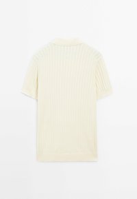 Polo shirt en tricot à manches courtes de couleur crème avec des côtes verticales et un col doux, présenté à plat sur un fond blanc.