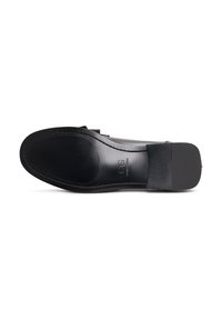 Scarpa in pelle nera con un design elegante, con una superficie liscia, punta arrotondata e suola piatta in gomma. Branding discreto sulla suola.