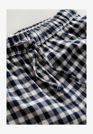 Puuvillashortsit, joissa on sinivalkoinen ruutukuosi. Elastinen vyötärö ja nauha säädettävää istuvuutta varten. Teksturoitu kangas.