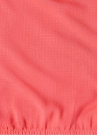 Tissu élastique rose corail avec une fine texture à petits pois et de douces plis, montrant des coutures froncées le long du bord inférieur.