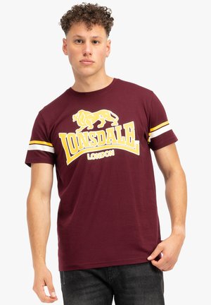 Tamsiai raudona medvilninė marškinė su geltonu liūto logotipu ir tekstu "Lonsdale LONDON", su baltomis ir geltonomis juostelėmis ant rankovių.