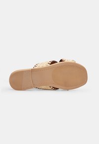 Flat-bottomed sandals with woven straw straps in beige and brown, featuring a rubber sole with a textured grip for stability.