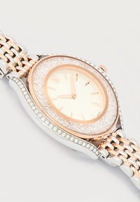 Ρολόι χειρός από ρόζ χρυσό και ασήμι με στεφάνη επενδυμένη με κρύσταλλα, μινιμαλιστικό καντράν με χρυσούς δείκτες και μεταλλικό λουράκι με συνδέσμους.