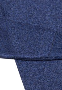 Țesătură tricotată de culoare albastru marin, cu un model texturat și melanj. Prezintă manșete și tiv cu benză, având un aspect moale și elastic.