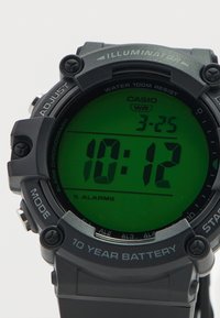 Ψηφιακό ρολόι με μαύρη πλαστική θήκη και λουράκι, πράσινη οθόνη LCD που δείχνει την ώρα 10:12, με κουμπιά επισημασμένα ως «ADJUST», «MODE» και «START».