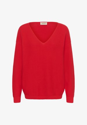 Punane V-kaelusega kampsun pikkade varrukatega, soonikkoes ja lahtise lõikega. Silt, millel on kirjutatud "CREAM", asub kaela tagaküljel.