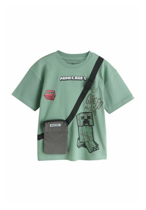 Zielona koszulka Minecraft z krótkim rękawem, z grafiką Creepera, blokiem TNT oraz dołączoną czarną torbą na ramię z etykietą Minecraft.