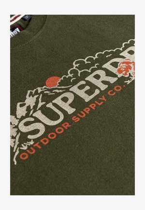 Felpa verde oliva con una finitura testurizzata, caratterizzata da una grande grafica bianca e rossa che include montagne e il testo "SUPERDRY OUTDOOR SUPPLY CO."