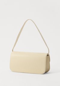 Bolso de hombro de cuero beige con forma rectangular, textura suave y una sola correa ajustable. Presenta un cierre de solapa y un diseño minimalista.