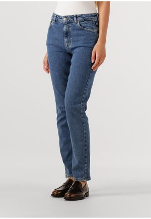 Plave traperice s ravnim nogavicama, s kopčanjem na gumb i patentni zatvarač, te prednjim džepovima. Glatka tekstura s klasičnim pranjem.