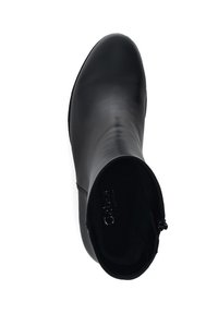 Bota de tobillo de cuero negro con acabado suave, puntera afilada y cierre de cremallera. El interior cuenta con un forro suave para mayor comodidad.