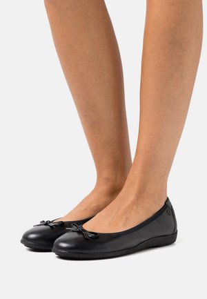 Zwarte leren ballerina's met een ronde neus, voorzien van een klein strikje aan de voorkant en een gladde textuur. Subtiele branding aan de zijkant.