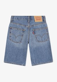 Μπλε τζιν σορτς με ευθεία κοπή, πίσω τσέπες με καμπυλωτό ράψιμο και δερμάτινη ετικέτα με το λογότυπο στη μέση.