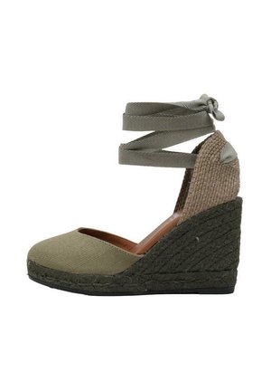 Espadrille à semelle compensée avec tige en toile vert olive, talon en jute tissé et détail de lien à la cheville. Bout arrondi et panneau latéral texturé.