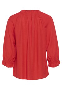 Rdeča lanena bluza z nabiranim ovratnikom, tridelnimi rokavi in volanastimi manšetami. Mehka tekstura in ohlapen kroj ustvarjata sproščen silhuet.