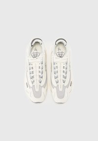 Baskets blanches avec tige en mesh et cuir, accents gris, bout arrondi, col rembourré et détails de logo sur la languette et le côté.