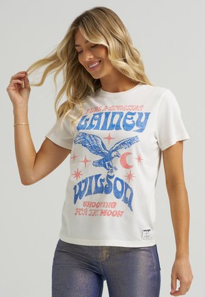 White short-sleeve t-shirt featuring denim-blue and pink graphic text, an eagle design, and stars. Made of cotton with a casual fit.
