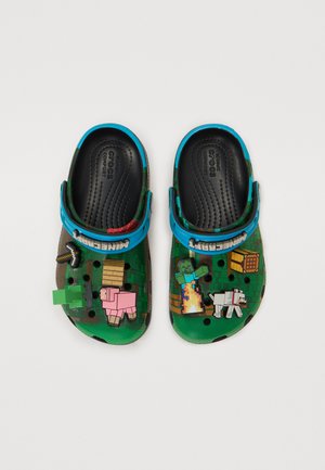 Des Crocs verts avec des graphismes sur le thème de Minecraft, une tige texturée, une sangle bleue et des charms en 3D ludiques. Un design léger et respirant.