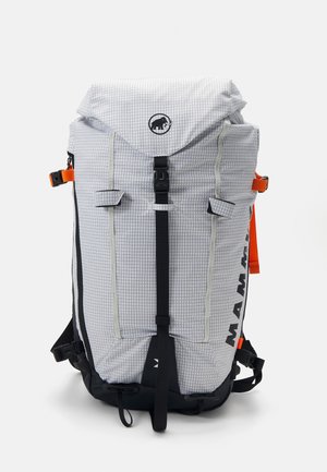 Backpack with a gray checkered pattern, featuring black and orange accents, top flap closure, adjustable straps, and exterior pockets.