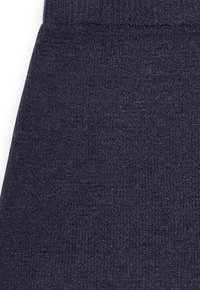 Dunkelnavyblau gestrickter Stoff mit feinem Rippenbund und strukturiertem Muster im unteren Teil eines Kleidungsstücks.