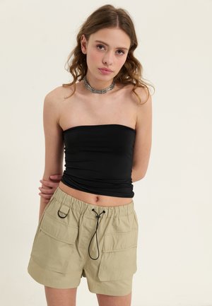 Must have väike ülemine osa, paari täiendava vööga heledaid khaki lühikesi pükse, mis sisaldavad elastset vööd ja paela. Tekstuurne kangas, küljetaskud.