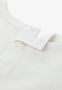 Weißes Baumwollkleidungsstück mit einem gerippten Rundhalsausschnitt und zwei Druckknöpfen am Kragen. Weicher Stoff und ein sauberes, schlichtes Design.