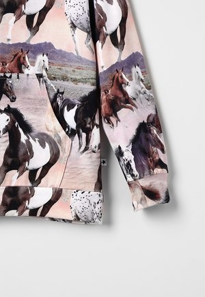 Langärmliges Kleidungsstück mit mehrfarbigen Pferden, die in einer Wüstenlandschaft vor einem Hintergrund aus violetten Bergen galoppieren.