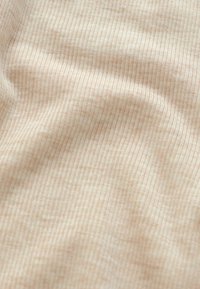 Lys beige stof med en subtil ribbet tekstur, der har fine vertikale linjer. Blød og glat overflade, der viser lette farvevariationer.