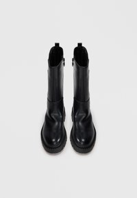 Black leather ankle boots with a smooth finish, rounded toe, and textured rubber sole. Features side zippers for easy wear.