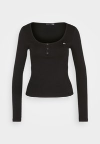 Schwarzes Langarmshirt mit Rundhalsausschnitt, drei vorderen Knöpfen und einer schmalen Passform mit gerippter Struktur. Kleines Logo-Detail.