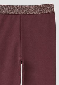 Bordeaux leggings met een glinsterende tailleband. Zacht, rekbaar materiaal met een gladde textuur. Heeft een aansluitend ontwerp en geen zichtbare naden.