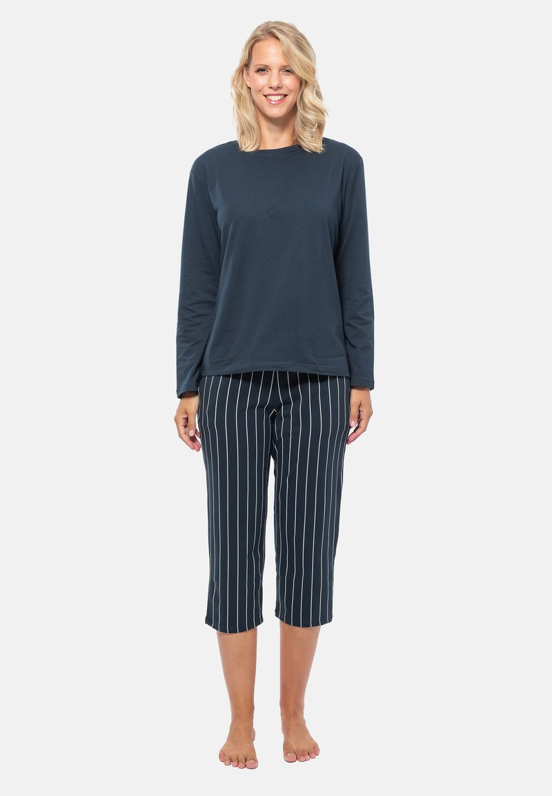 Marineblauw overhemd met lange mouwen in combinatie met knielange gestreepte broek, met verticale witte strepen. Zachte stof met een relaxte pasvorm.