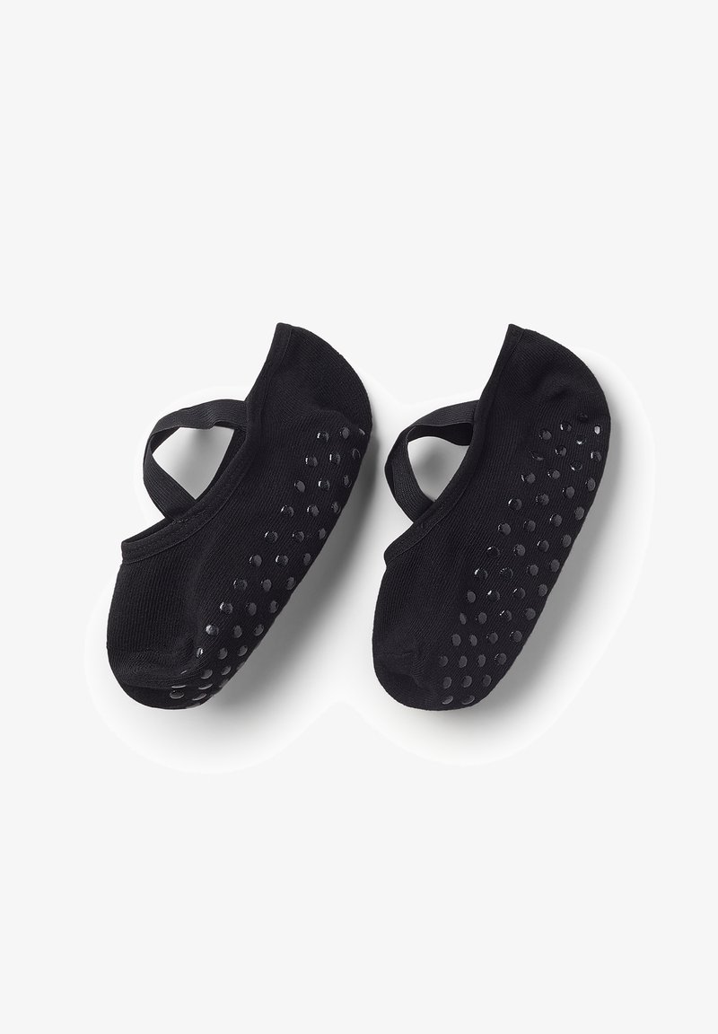 Calze nere antiscivolo in stile balletto con cinturini elastici e puntini di gomma antiscivolo sulle suole, mostrati su uno sfondo bianco.