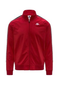 Giacca a track rossa con zip, realizzata in tessuto liscio, presenta strisce laterali nere e un piccolo logo bianco nella parte superiore sinistra del petto.