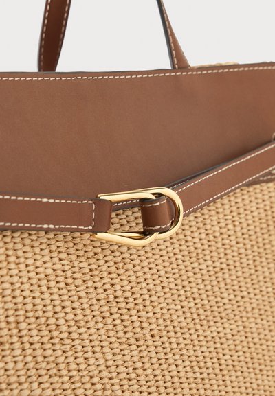 Καφέ δερμάτινη και πλεγμένη τσάντα από άχυρο με μπεζ ραφές και χρυσή πόρπη στη λουρίδα.