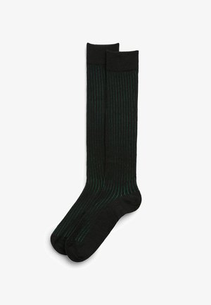 Calze nere fino al ginocchio con sottili strisce verticali verdi, una texture liscia e un comodo polsino a costine nella parte superiore.