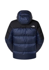 Marinblå pufferjacka med svarta axlar, stor huva och kviltade sektioner för isolering. Med The North Face-logotypen på baksidan.