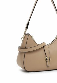 Beige Leder Schultertasche mit schwarzen Akzenten, geschwungener Form, einem Schulterriemen und einem runden Metall-Logo-Detail auf der Vorderseite. Mit Reißverschluss.