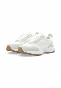 Weiße Sportschuhe mit einer strukturierten Wildlederoberfläche, flachen Schnürsenkeln und einer Gummisohle mit Zickzackmuster. Sie haben ein minimalistisches Design.