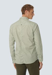 Langarmshirt met een lichtgroene basis, bedekt met kleine geometrische vormen in blauw en beige. Heeft een kraag met knopen en een afgeronde zoom.