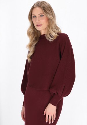 Burgunderfarbener Rippstrickpullover mit Ballonärmeln, strukturiertem Stoff, rundem Kragen und taillierter Passform, kombiniert mit einem passenden Rock.